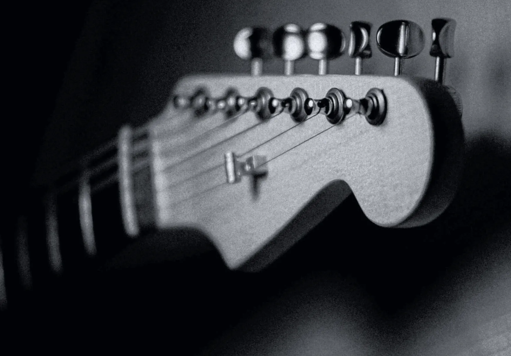 Black and white close-up of the Solic Arc headstock and tuners, shot with a shallow depth of field.