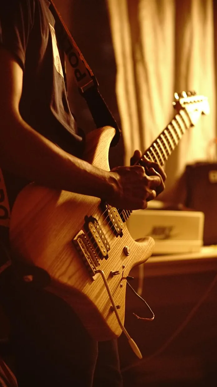 Close-up of hands on Solic Arc in warm lamplight.