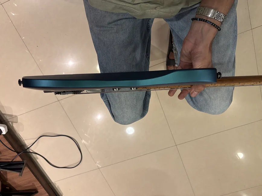 Edge-on view of the same headless guitar, showing the thin body profile.