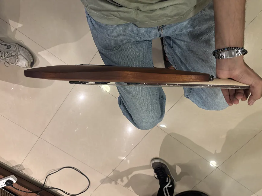 Edge-on view of the mahogany guitar, showing its thicker body.
